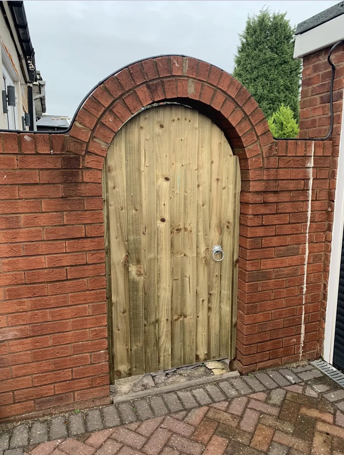 Made-to-measure Kingswood garden gate fitted in an arched brick opening